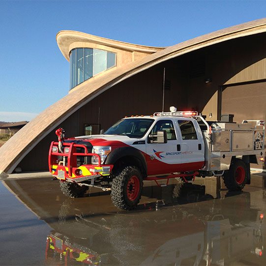 A fire truck parked in front of the terminal building at Spaceport America in New Mexico.